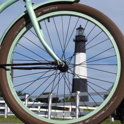The Tybee Island lighthouse framed inside the wheel of one of our mint green cruisers